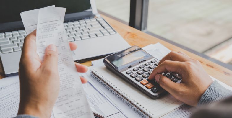 young-man-using-calculator-and-calculate-bills-in-home-office